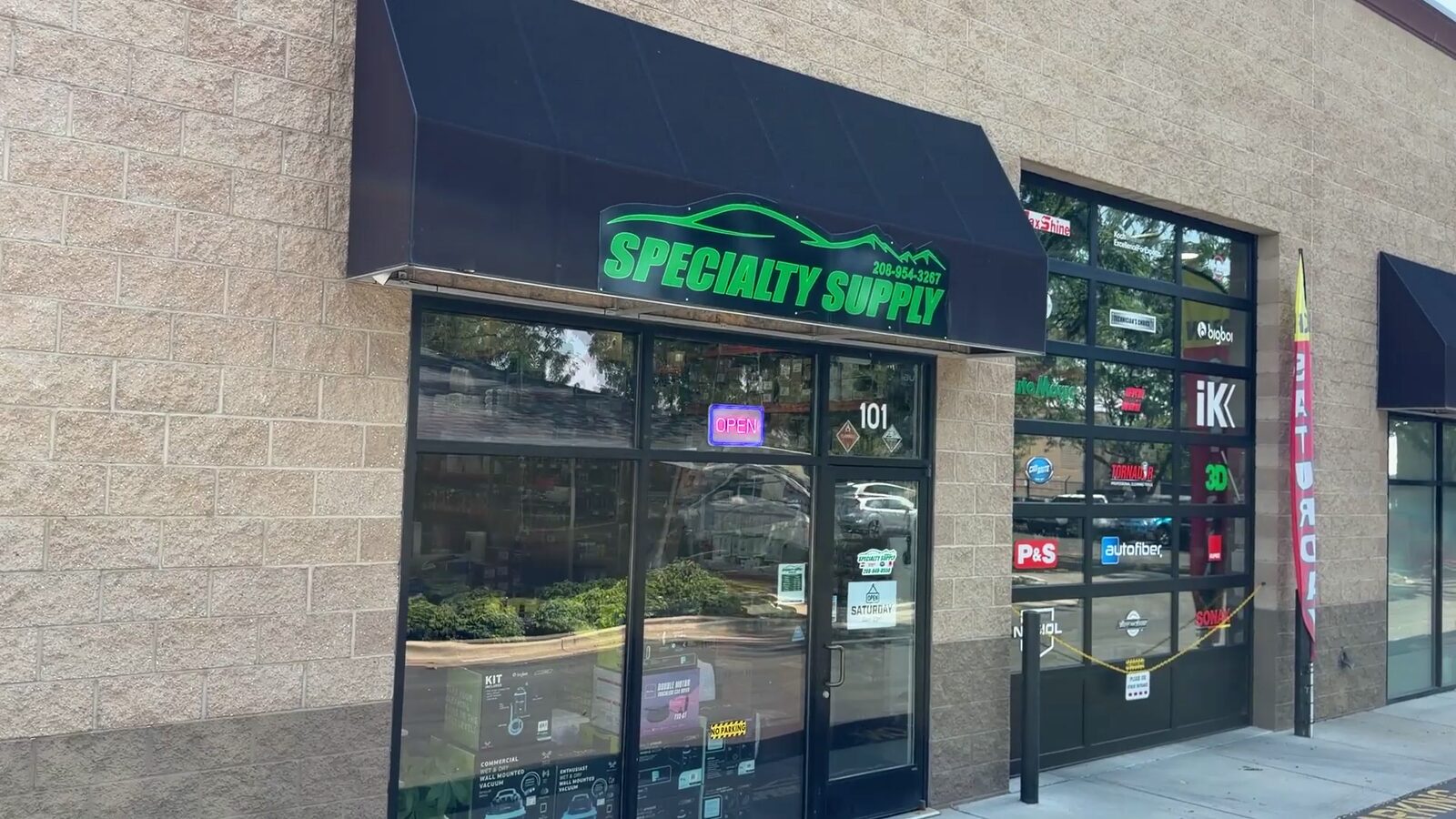 Front door of the Specialty Supply store under the black awning on E Pine Ave